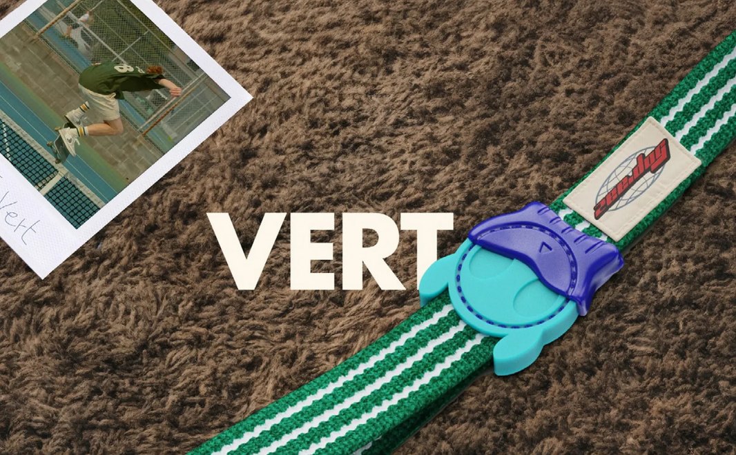 Collar Vert en verde y blanco con hebilla morada y turquesa sobre alfombra café